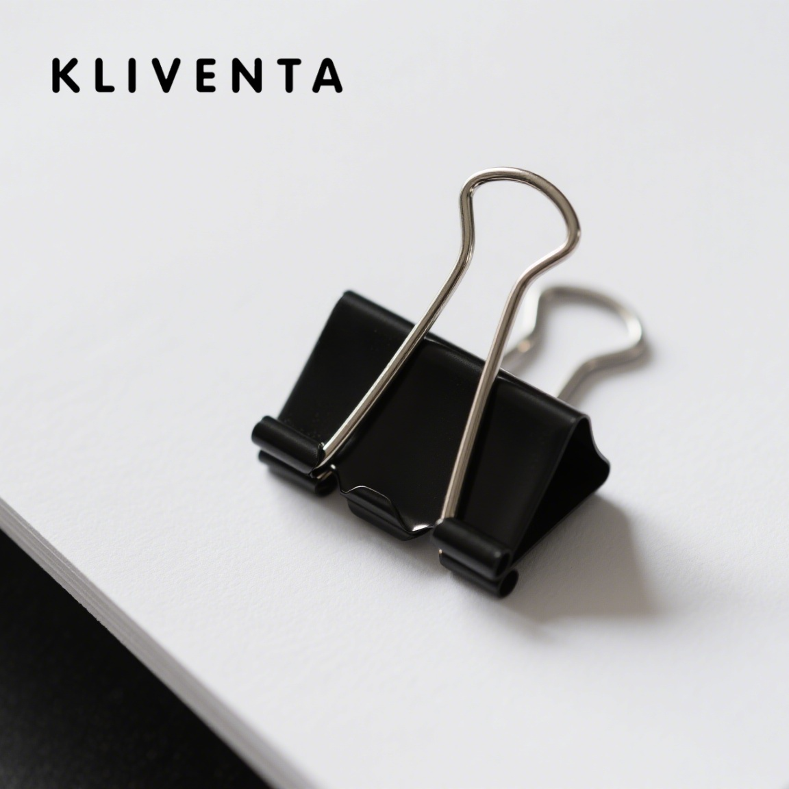 Close-up of silver metal paper clip on white background
