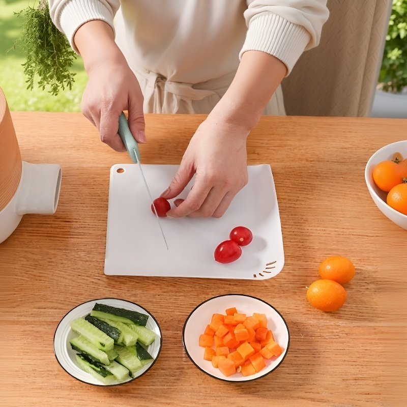 Vegetables being chopped on hangable cutting board with drainage holes