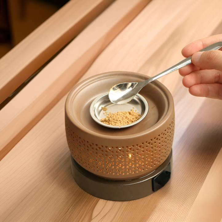 Quemador de aroma con vela encendida y aceites esenciales