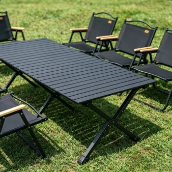 Folding camping table and chairs set up at a picnic site