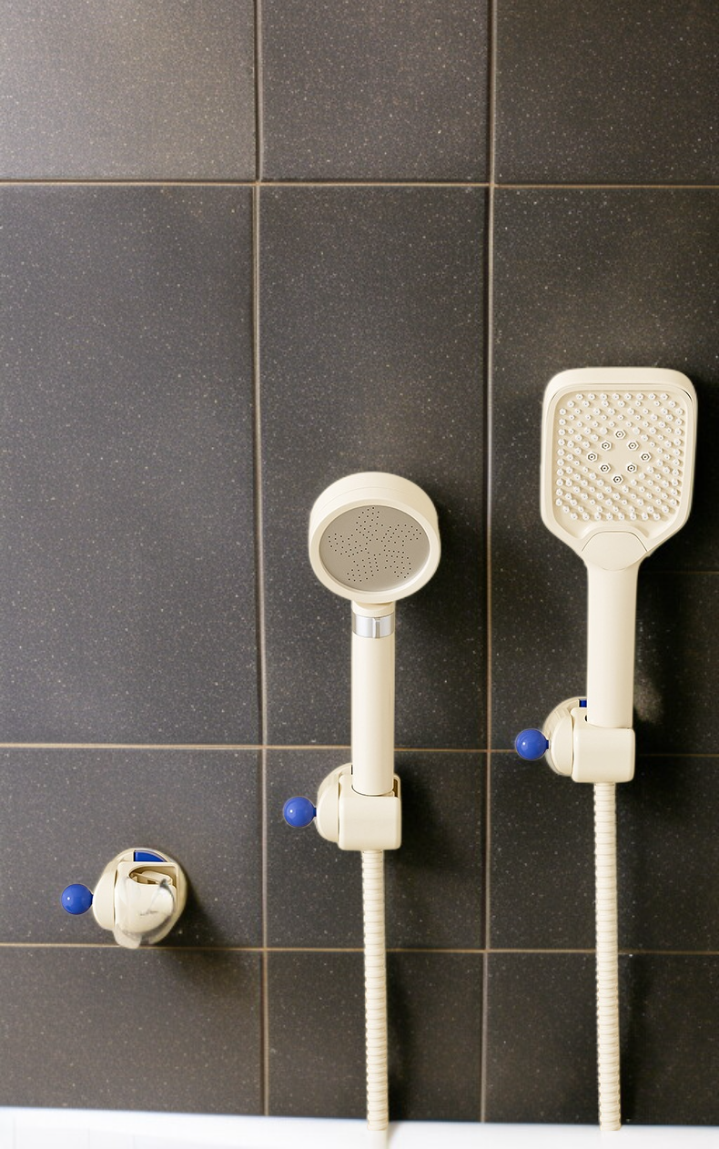 욕실 벽에 빨판으로 고정된 샤워기 받침대