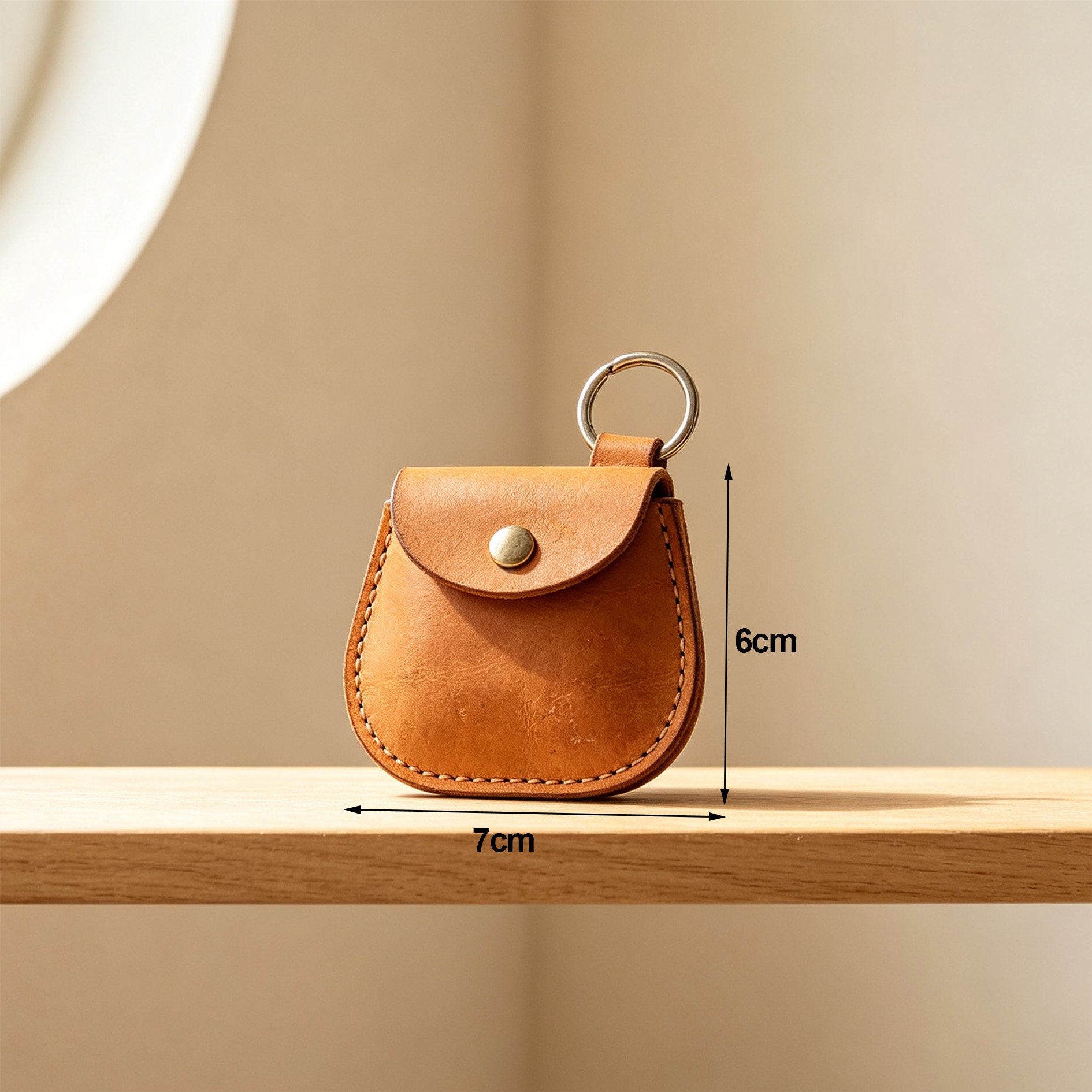 Hand holding a leather key pouch with keys inside